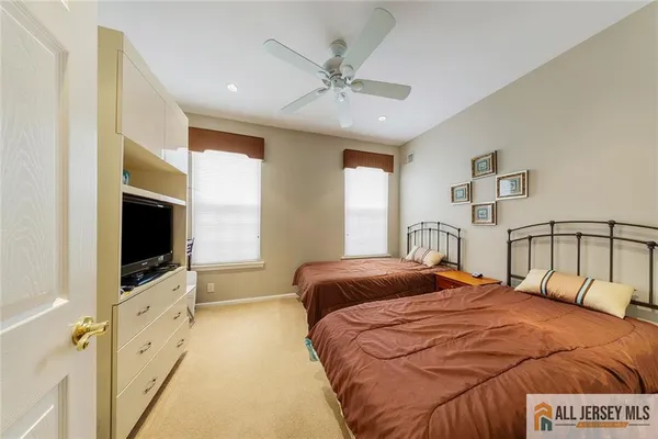 a bedroom with a bed and a flat tv screen on dresser