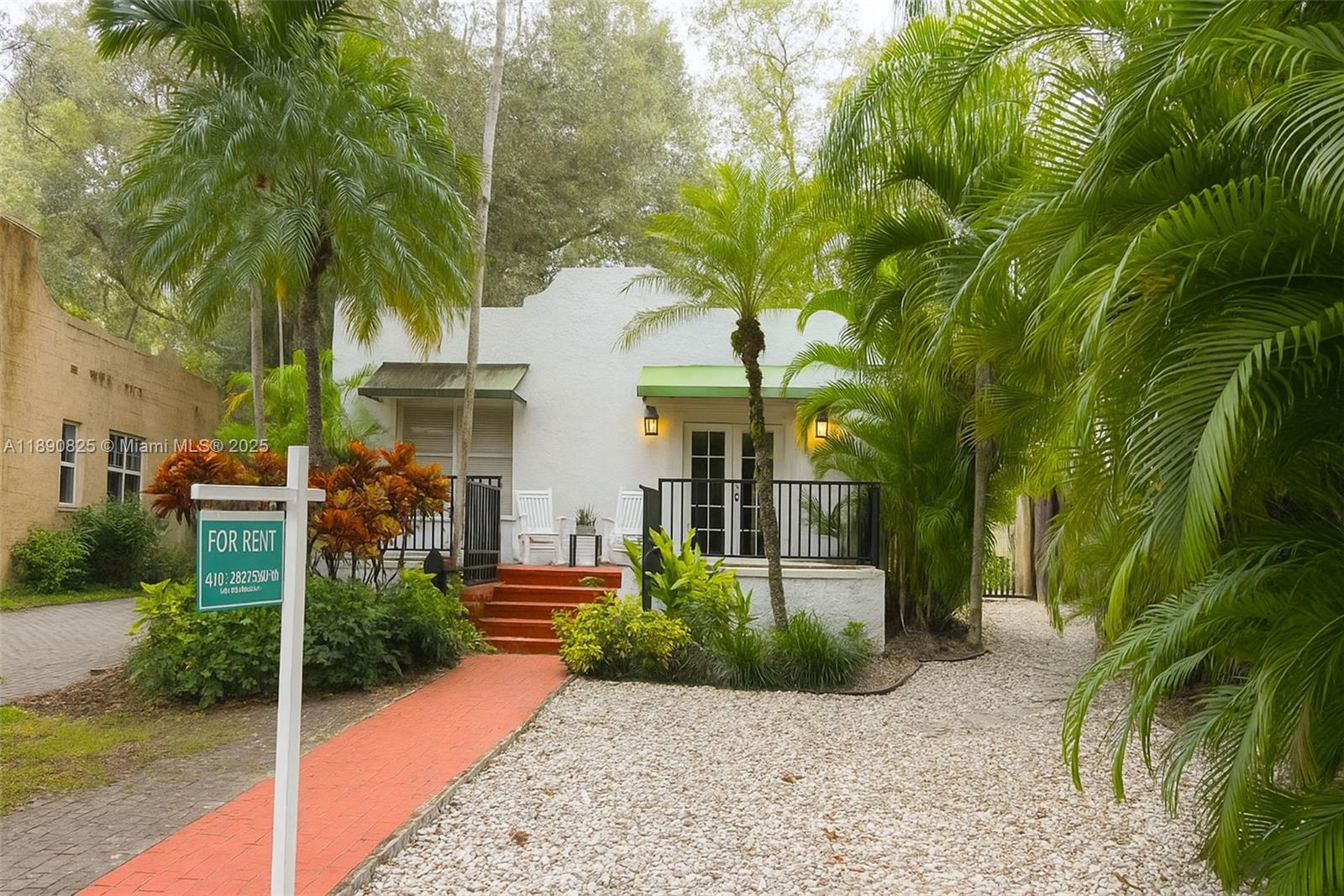 1856 Opechee Drive, Unit 2 Miami, FL 33133 - Photo 14 of 15 a view of a white house with a yard and potted plants