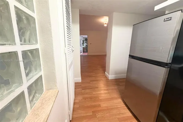 a view of a hallway with wooden floor and staircase