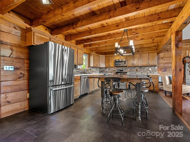 a kitchen with stainless steel appliances granite countertop a stove a sink dishwasher and cabinets with wooden floor