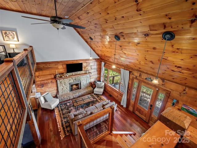 a living room with a rug floor to ceiling window and a wooden floor