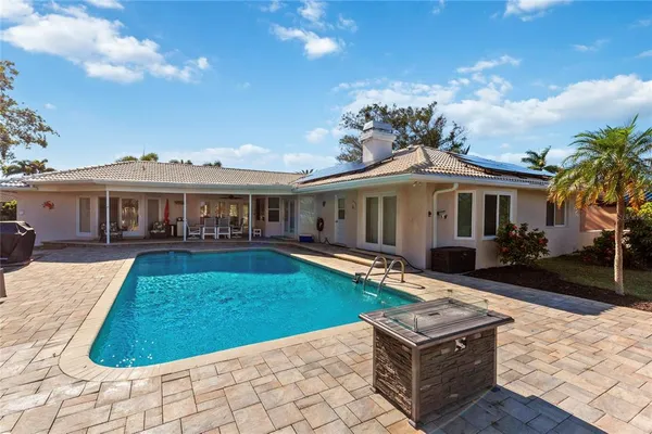 a kitchen with stainless steel appliances a refrigerator a stove a sink a dining table and chairs