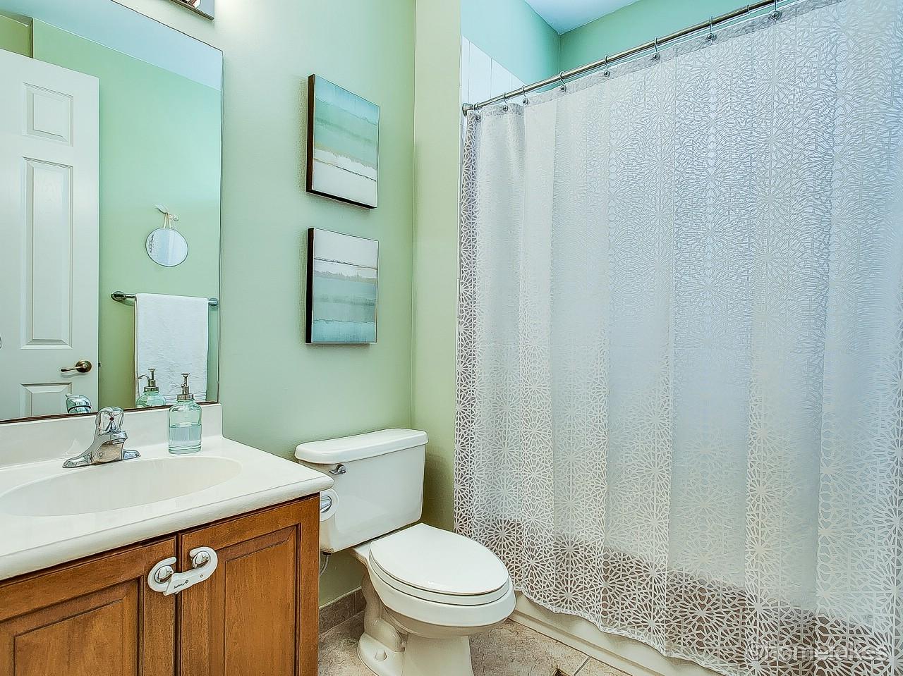 4308 Blowing Point Place Jupiter, FL 33458 - Photo 15 of 21 a bathroom with a sink a toilet and shower curtain