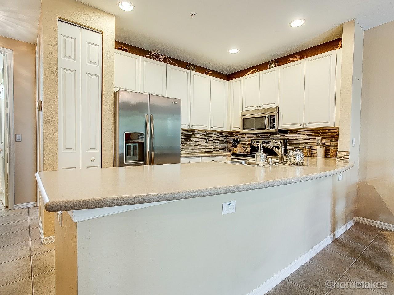 4308 Blowing Point Place Jupiter, FL 33458 - Photo 7 of 21 a kitchen with stainless steel appliances granite countertop a sink a stove and refrigerator