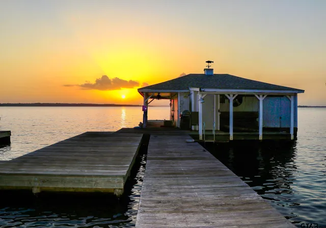 a view of a roof deck with table and chairs under an umbrella with wooden floor