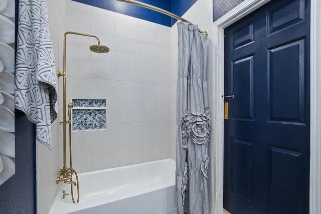 a bathroom with a bathtub and shower