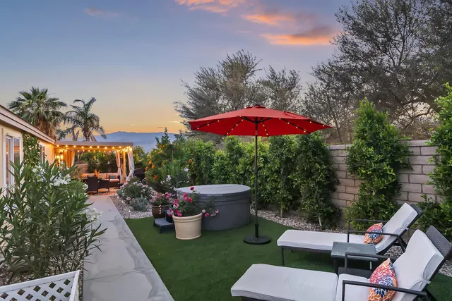 a patio with a table and chairs under an umbrella