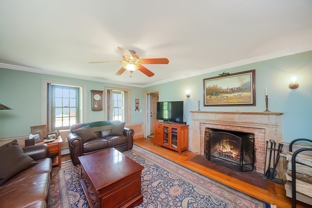 338 Neck Road Lancaster, MA 01523 - Photo 17 of 42 a living room with furniture a fireplace and a flat screen tv