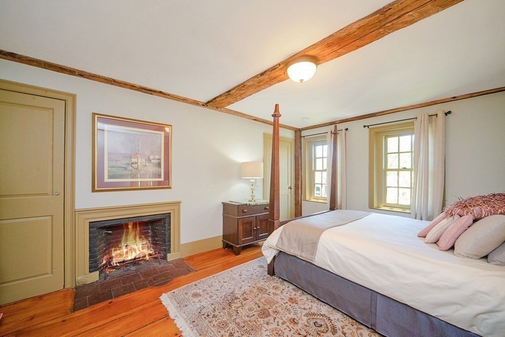 338 Neck Road Lancaster, MA 01523 - Photo 28 of 42 a bedroom with a bed and a fireplace