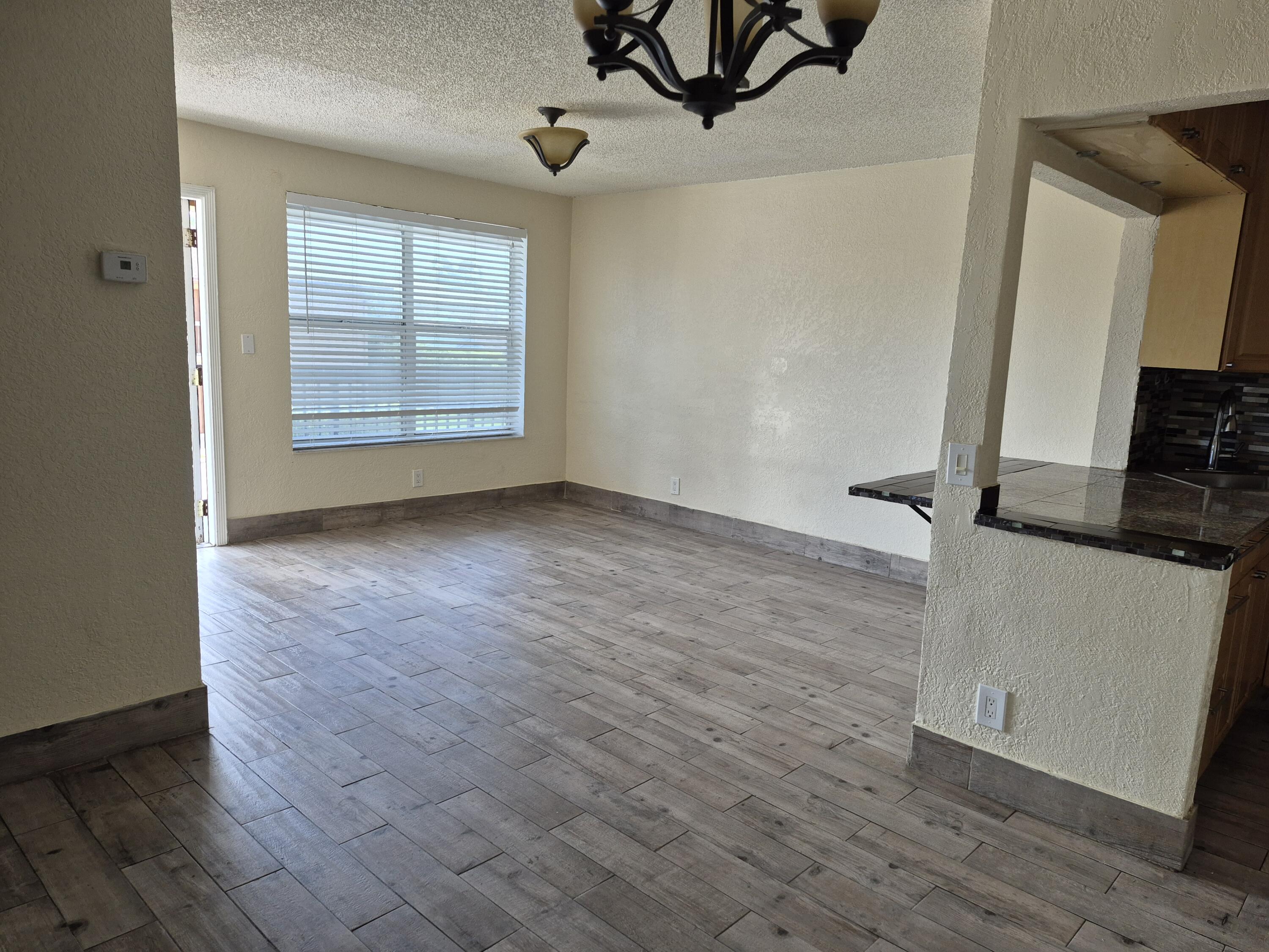10039 Winding Lake Road, Unit 202 Sunrise, FL 33351 - Photo 6 of 14 wooden floor in an empty room with a window
