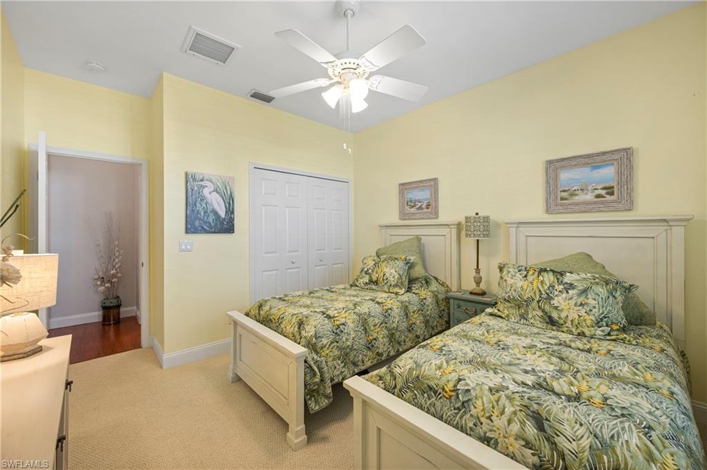 1742 Marsh Run Naples, FL 34109 - Photo 11 of 31 a spacious bedroom with two bed and a chandelier