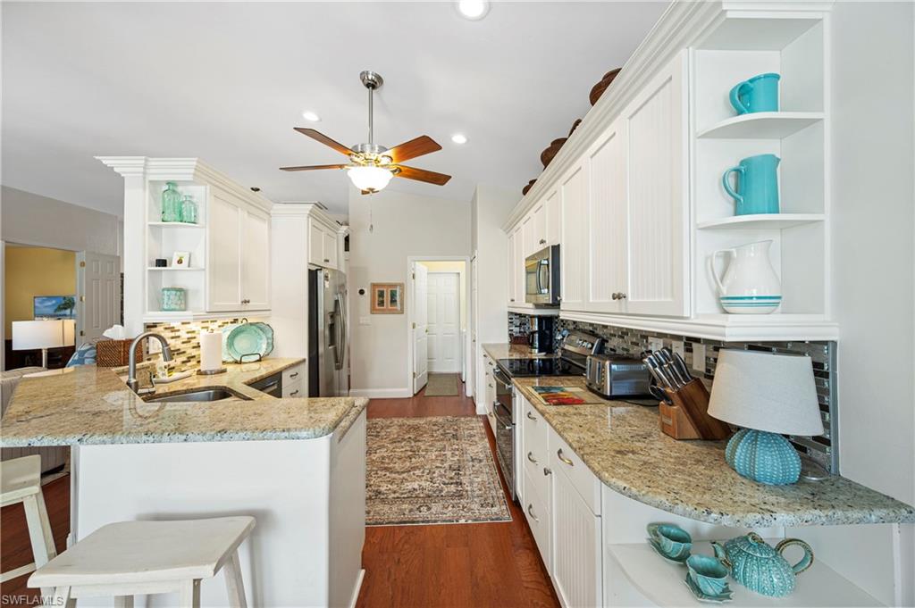 1742 Marsh Run Naples, FL 34109 - Photo 14 of 31 a kitchen with granite countertop a sink a stove and refrigerator