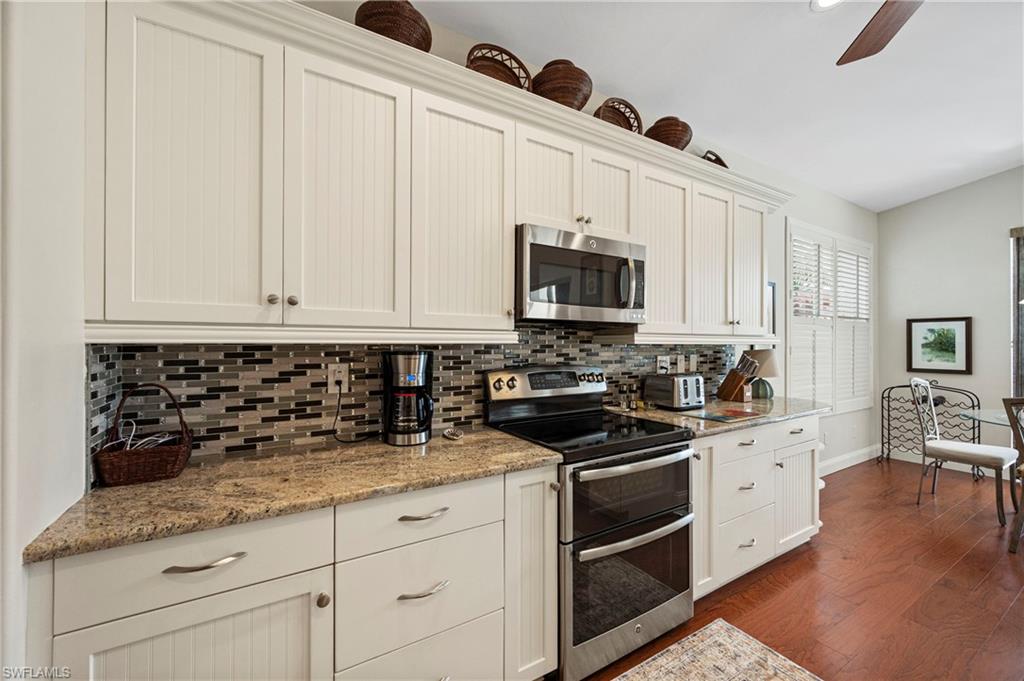 1742 Marsh Run Naples, FL 34109 - Photo 16 of 31 a kitchen with granite countertop white cabinets and stainless steel appliances