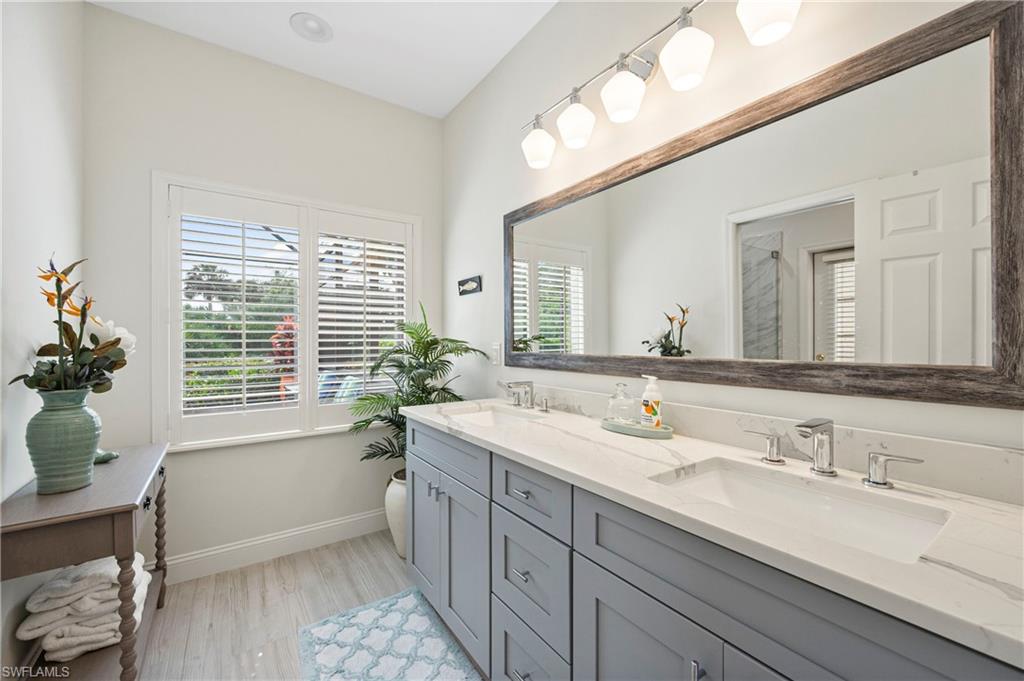 1742 Marsh Run Naples, FL 34109 - Photo 21 of 31 a bathroom with a granite countertop sink a large mirror a bathtub and window