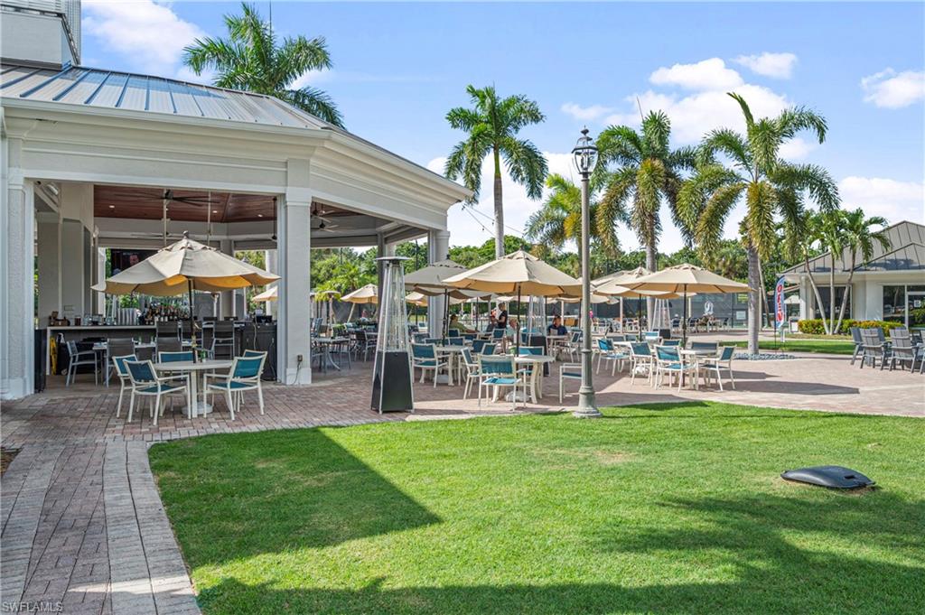 1742 Marsh Run Naples, FL 34109 - Photo 29 of 31 a patio with a table and chairs under an umbrella