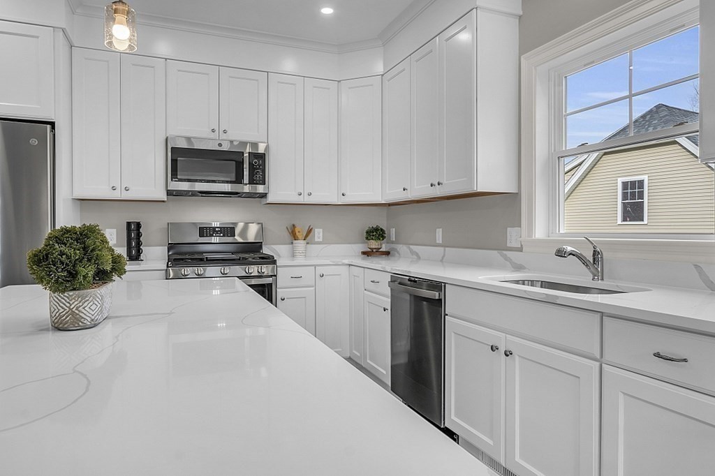 5 Boot Shop Road, Unit 31 Upton, MA 01568 - Photo 5 of 28 a kitchen with stainless steel appliances granite countertop a sink a stove a microwave and cabinets