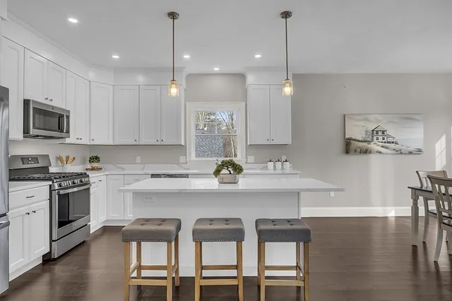 a kitchen with a dining table chairs sink and cabinets