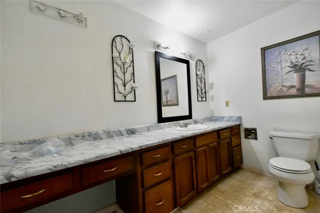 a bathroom with a granite countertop sink mirror vanity and toilet