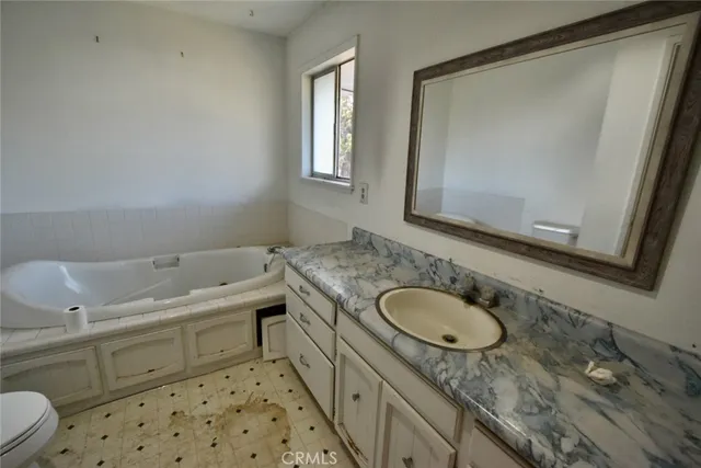 a bathroom with a granite countertop sink toilet and mirror