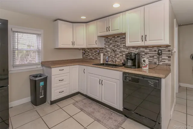 a kitchen with granite countertop white cabinets and white appliances