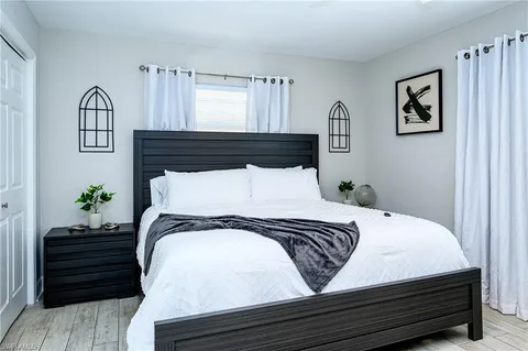 a bedroom with a bed and painting on the wall