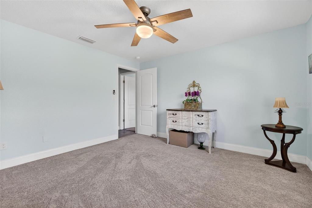 2811 Rampart Circle, Unit 2811 Clearwater, FL 33761 - Photo 21 of 30 a room that has a piano and a chandelier fan