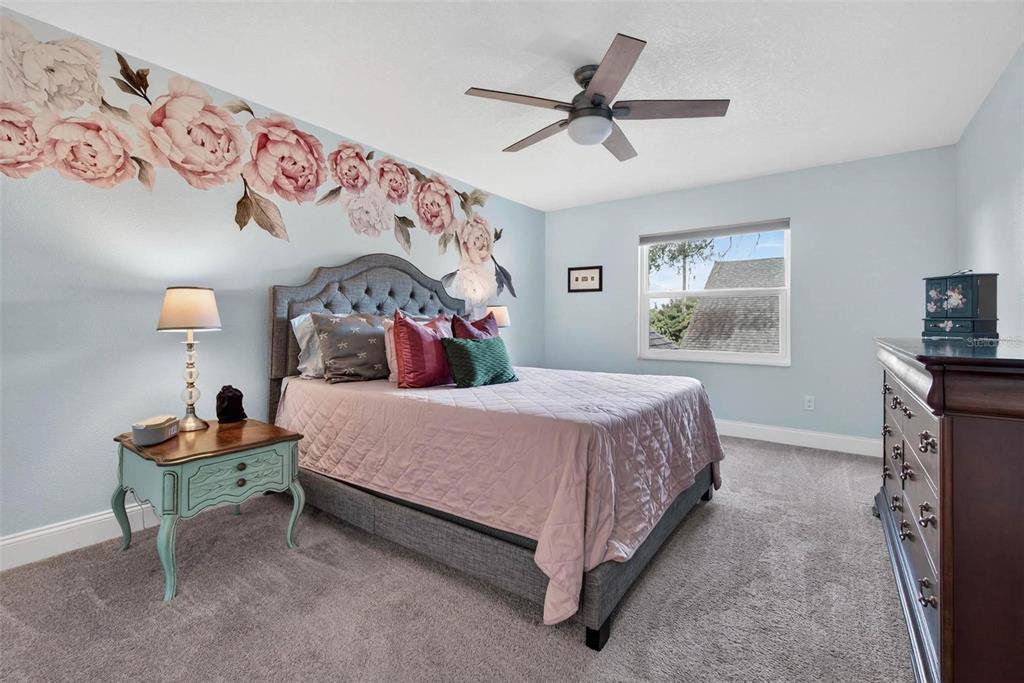 2811 Rampart Circle, Unit 2811 Clearwater, FL 33761 - Photo 23 of 30 a bedroom with a bed and a chandelier
