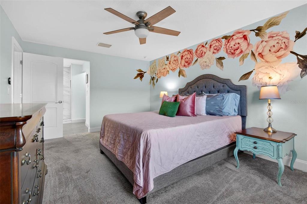 2811 Rampart Circle, Unit 2811 Clearwater, FL 33761 - Photo 24 of 30 a bedroom with a bed and a chandelier