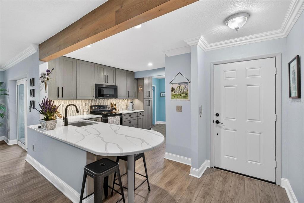 2811 Rampart Circle, Unit 2811 Clearwater, FL 33761 - Photo 5 of 30 a kitchen with granite countertop a table chairs microwave and refrigerator
