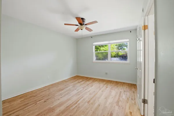 a view of empty room with wooden floor and window