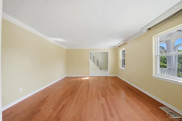 a view of a room with wooden floor chandelier and a window