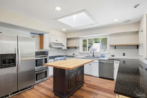 a kitchen with a stove a sink and a refrigerator