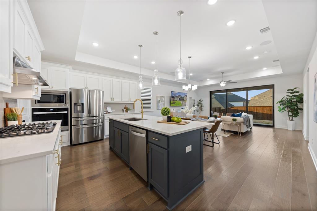 a kitchen with a sink stove and wooden floor