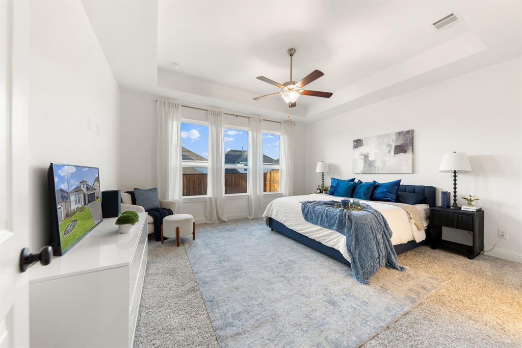 1517 Miranda Lane Denton, TX 76210 - Photo 14 of 37 a spacious bedroom with a bed couches and a flat tv screen