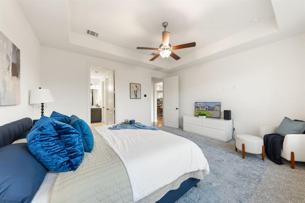 1517 Miranda Lane Denton, TX 76210 - Photo 15 of 37 a spacious bedroom with a bed a chandelier and a couch