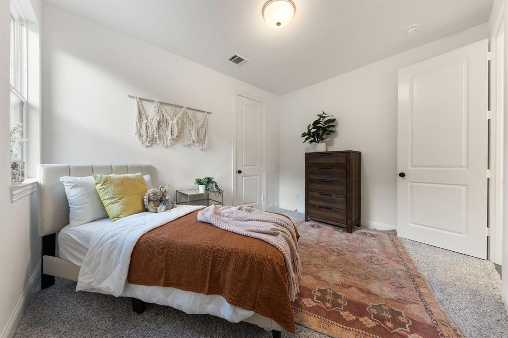 1517 Miranda Lane Denton, TX 76210 - Photo 18 of 37 a bedroom with a bed and a chandelier