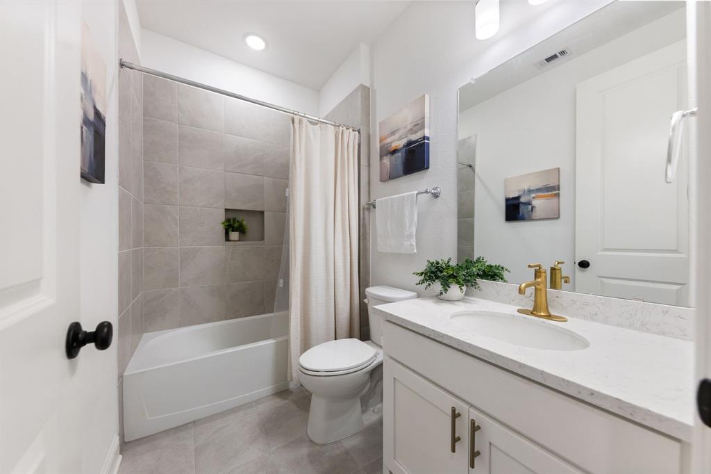 1517 Miranda Lane Denton, TX 76210 - Photo 19 of 37 a bathroom with a sink a toilet a mirror and shower