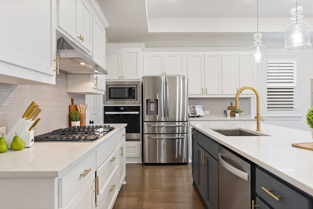 1517 Miranda Lane Denton, TX 76210 - Photo 7 of 37 a kitchen with stainless steel appliances kitchen island a refrigerator sink and stove