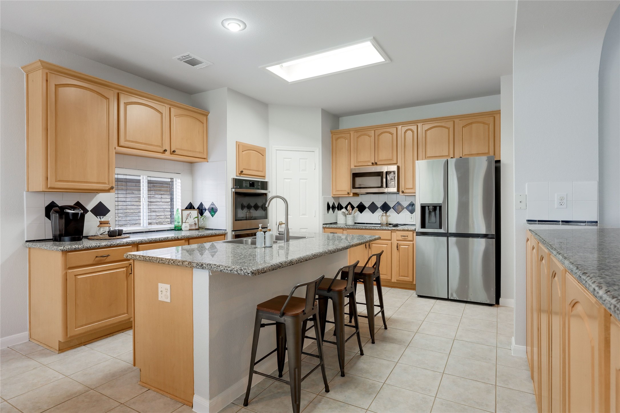 225 Trophy Pass Austin, TX 78748 - Photo 3 of 30 An oversized island is the perfect sport for a quick snack or homework zone.