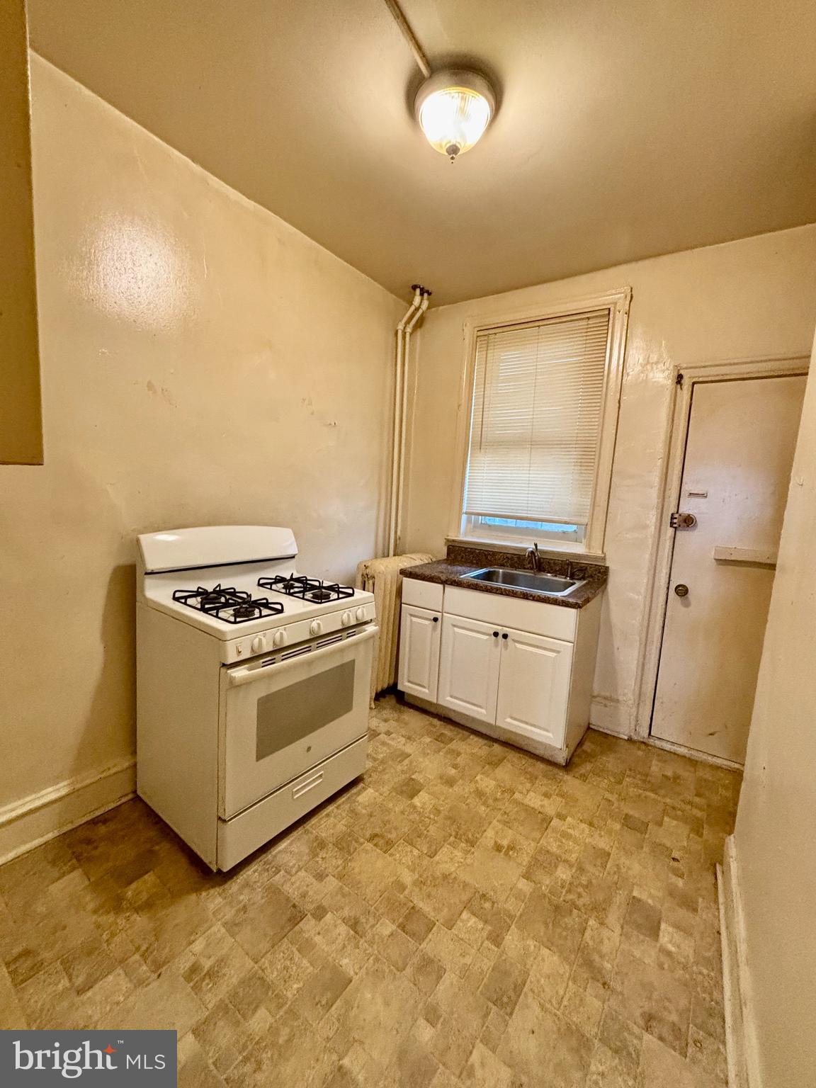 134 North Ruby Street Philadelphia, PA 19139 - Photo 14 of 34 a kitchen with granite countertop a stove and a refrigerator
