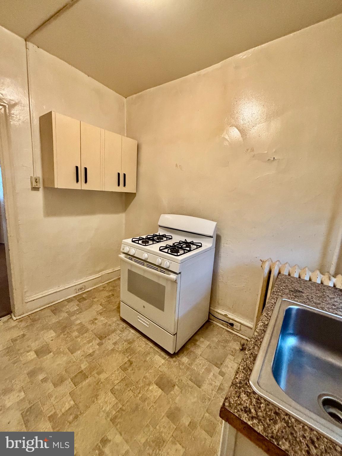 134 North Ruby Street Philadelphia, PA 19139 - Photo 15 of 34 a kitchen with granite countertop a stove and a sink