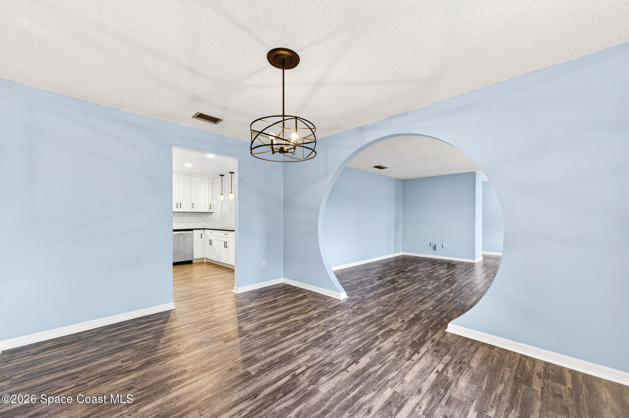 990 Boxford Lane Rockledge, FL 32955 - Photo 13 of 41 a view of a hallway with wooden floor a chandelier and entryway