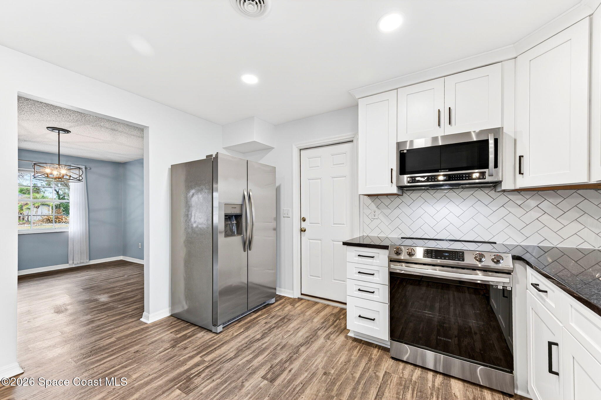 990 Boxford Lane Rockledge, FL 32955 - Photo 15 of 41 a kitchen with stainless steel appliances a stove a microwave and a hard wood floors