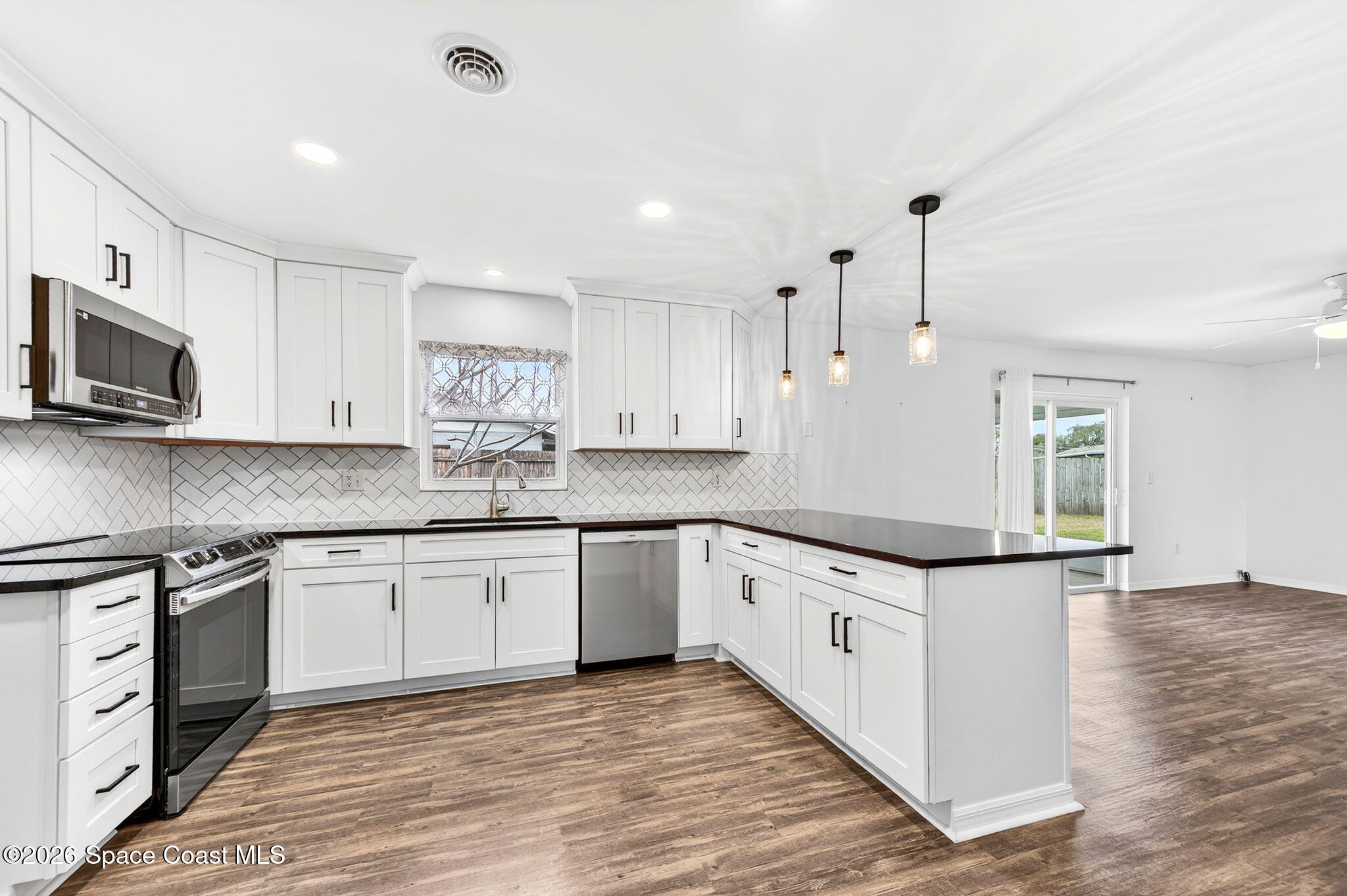 990 Boxford Lane Rockledge, FL 32955 - Photo 18 of 41 a kitchen with granite countertop a sink and steel appliances