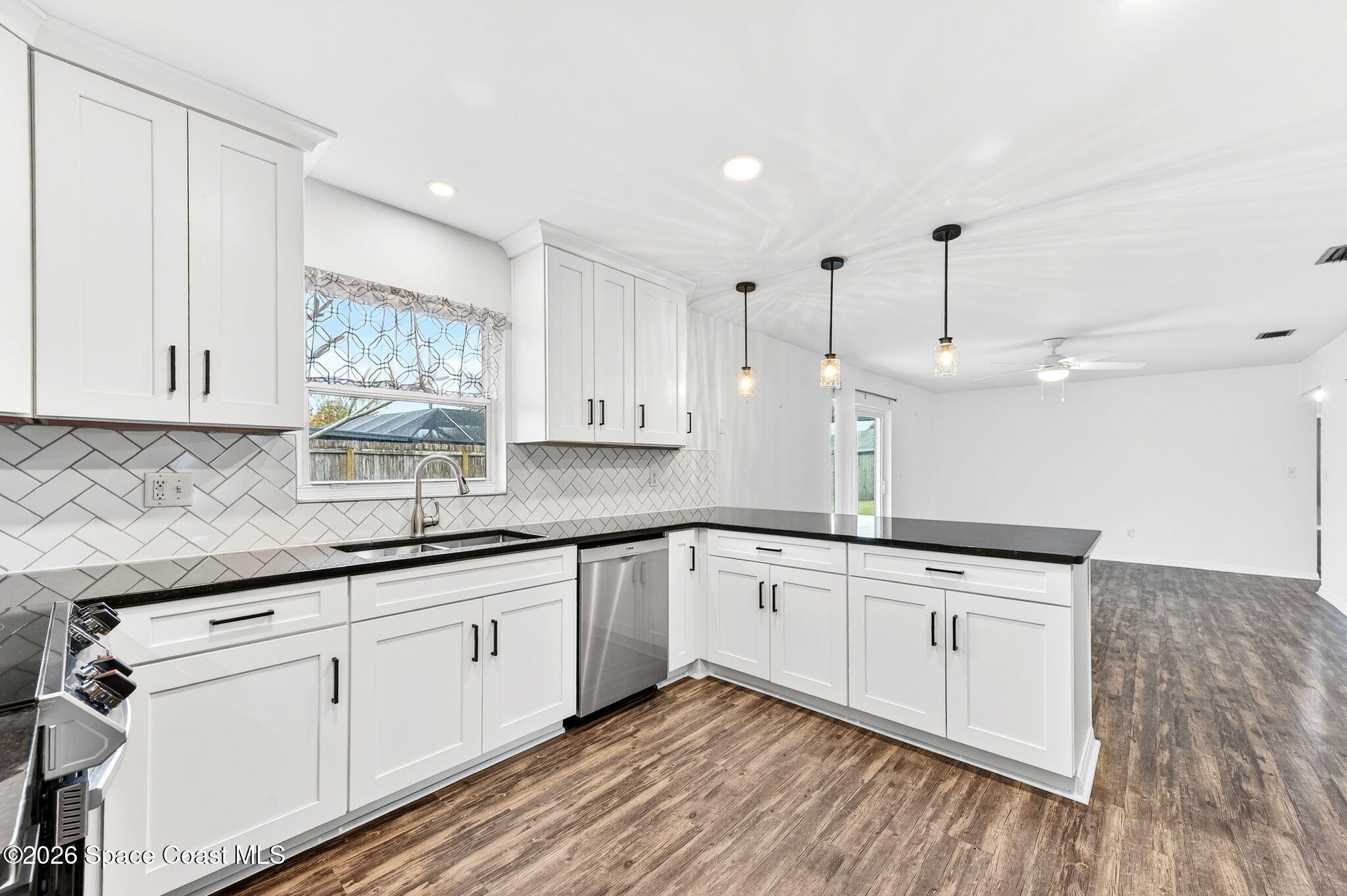 990 Boxford Lane Rockledge, FL 32955 - Photo 19 of 41 a kitchen with granite countertop white cabinets white appliances and granite counter tops