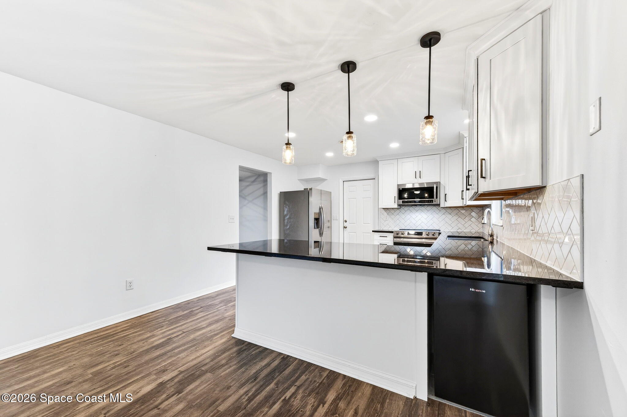 990 Boxford Lane Rockledge, FL 32955 - Photo 20 of 41 a kitchen with stainless steel appliances granite countertop a sink a stove and a wooden floor