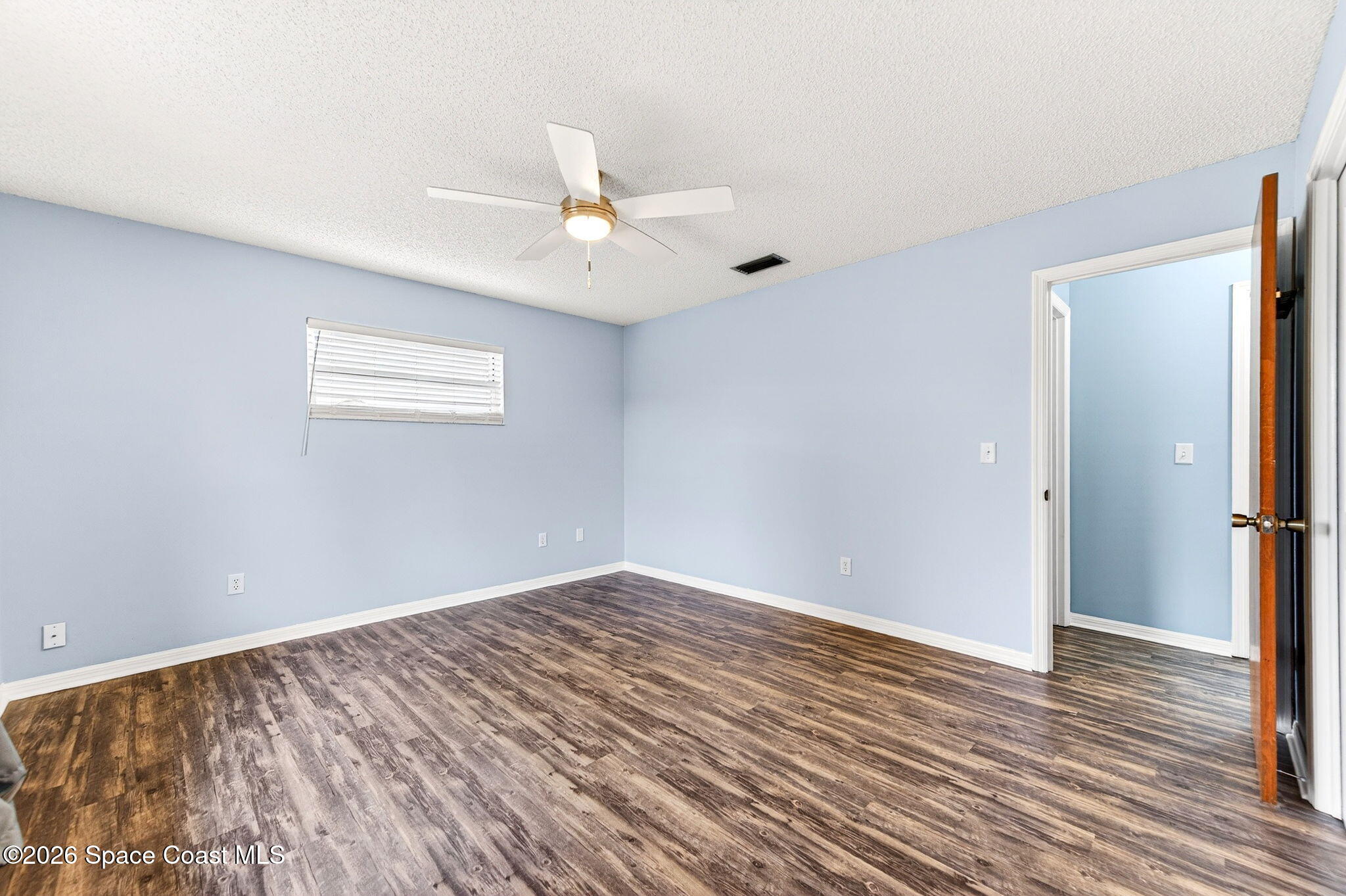 990 Boxford Lane Rockledge, FL 32955 - Photo 27 of 41 an empty room with wooden floor fan and windows