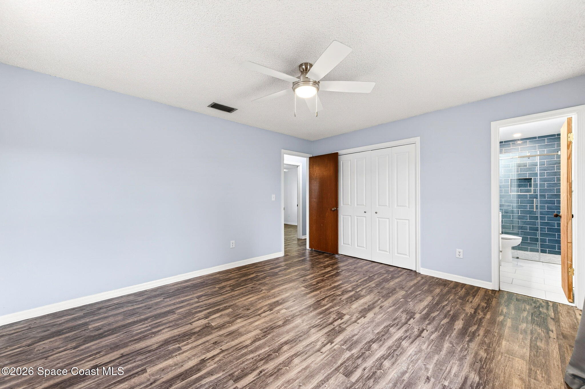 990 Boxford Lane Rockledge, FL 32955 - Photo 28 of 41 a view of an empty room with wooden floor and a ceiling fan