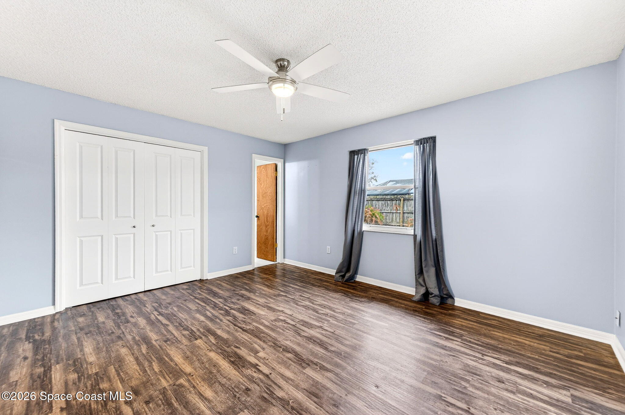 990 Boxford Lane Rockledge, FL 32955 - Photo 30 of 41 a view of an empty room with window and wooden floor