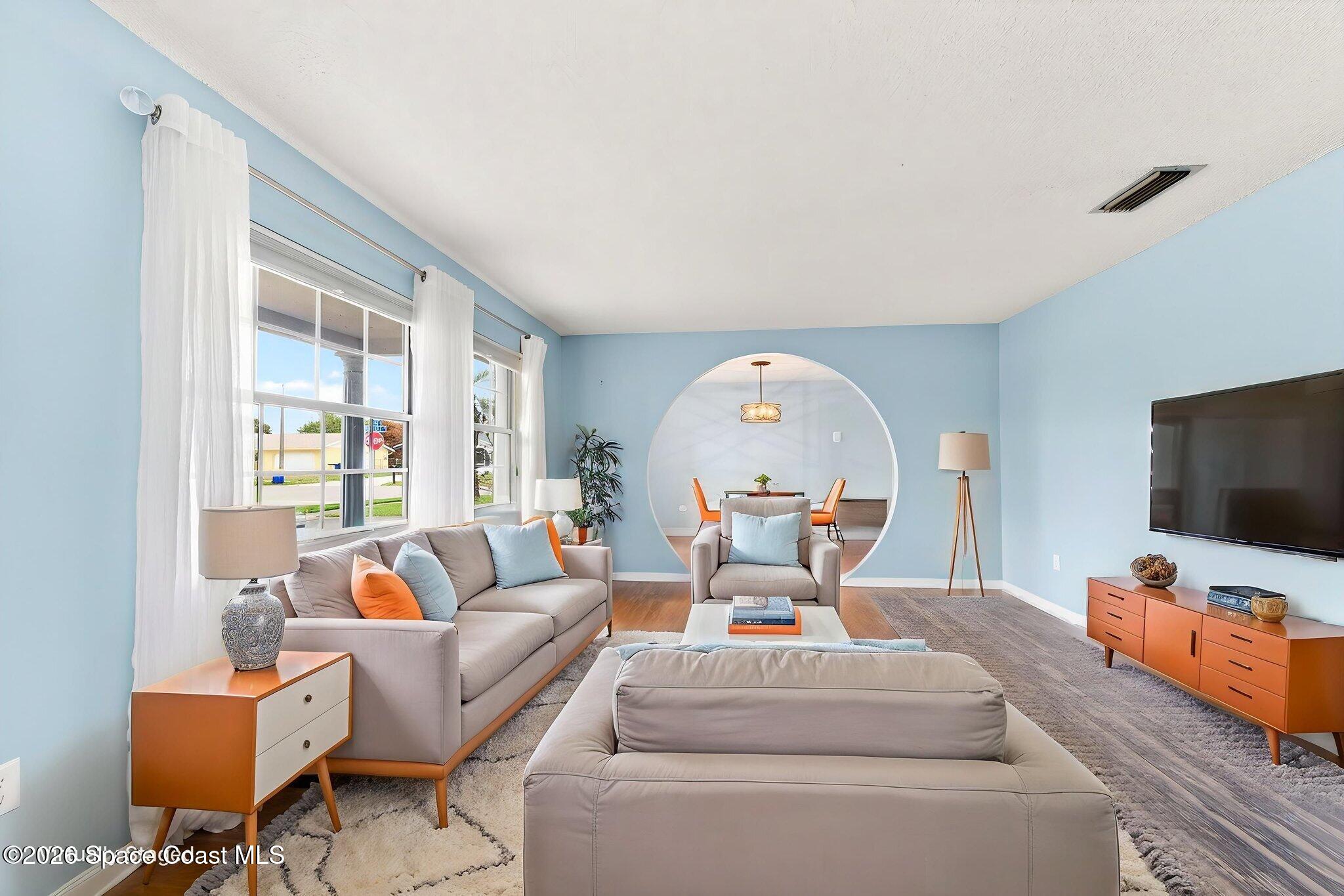 990 Boxford Lane Rockledge, FL 32955 - Photo 9 of 41 a living room with furniture a flat screen tv and a large window